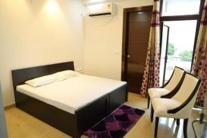 1 dormitorio con 1 cama, 1 silla y 1 ventana en Awsome Property Someone Will Love To Live num001, en Rishīkesh