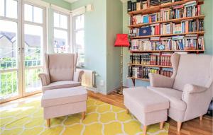 a living room with two chairs and a book shelf at Awesome Home In Limhamn With House Sea View in Malmö