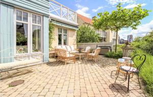 a patio with chairs and a table in a yard at Awesome Home In Limhamn With House Sea View in Malmö