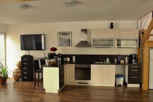 a kitchen with white and black cabinets and a table at Private holiday house Vivendi in Liptovský Mikuláš