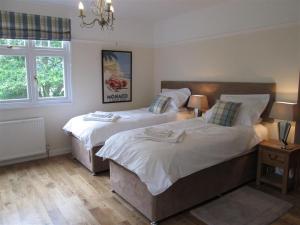 a bedroom with two beds and a window at Shieling Beag in Banchory