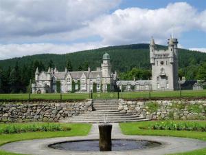 an old castle with a fountain in front of it at Shieling Beag in Banchory