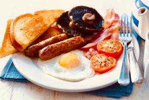 un plato de desayuno con salchichas de tocino y tostadas en The Lovat Hotel en Perth