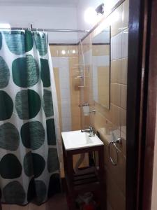 y baño con lavabo y ducha con cortina de ducha. en Departamento Punto Mogotes, Mar del Plata en Mar del Plata