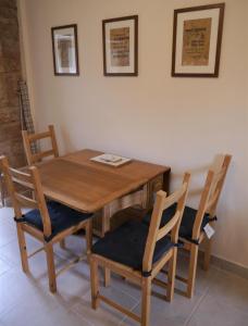 a wooden dining room table with four chairs at Laurieknowe Coach House in Dumfries