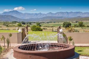 a water fountain with mountains in the background at Surval Boutique Olive Estate in Oudtshoorn