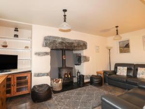 a living room with a fireplace and a couch at Ty'n y Clawdd in Dyffryn