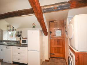 a kitchen with white appliances and a wooden door at Ty'n y Clawdd in Dyffryn