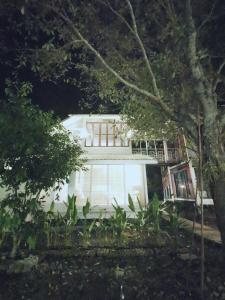 Casa blanca con balcón en la parte superior. en Baangaimuan, en Lamphun