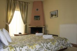 a bedroom with a large bed with a fireplace at Agrafa in Kerasea