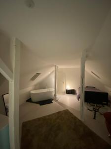 een witte kamer met een bad en een slaapkamer bij Superbe Duplex Strasbourg in Schiltigheim