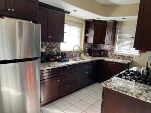 a kitchen with wooden cabinets and a stainless steel refrigerator at Lucky House in Long Beach