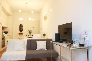 uma sala de estar com uma cadeira e uma mesa com uma televisão em Aliados Sunny Flat no Porto