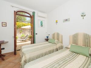 twee bedden in een kamer met een tafel en een raam bij IL TULIPANO - sea view, roof terrace & sunset in villa in Massa Lubrense