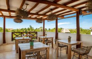 a restaurant with wooden tables and chairs and a view at El Corazón Boutique Hotel - Adults Only with Pool & Beach Club Access in Holbox Island