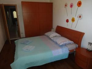 a bedroom with a bed with flowers on the wall at Centralni B4 in Igrane