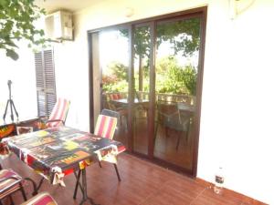 a room with a table and chairs on a patio at Centralni B4 in Igrane