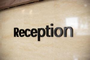 a sign on a wall with the word reception at Sunstone Hotel in George Town