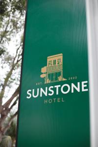 a sign for a sunstone hotel on a green at Sunstone Hotel in George Town