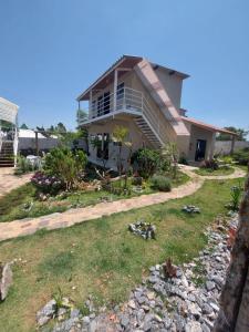 a house with a balcony and a yard at Pousada Ostara in Alto Paraíso de Goiás