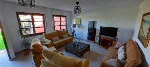 a living room with couches and a flat screen tv at Vivienda Vacacional El Robledo in Colombres