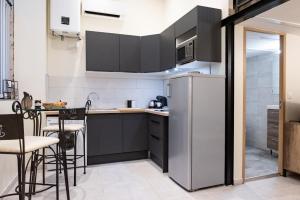 een keuken met een koelkast en een tafel en stoelen bij Duplex Ivoire au coeur de Montauban in Montauban