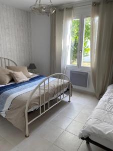 una camera bianca con un letto e una finestra di Maison lumineuse à Ars en ré ad Ars-en-Ré
