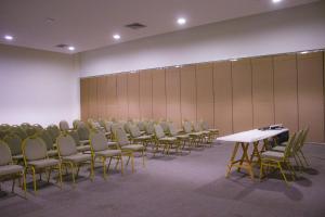 una stanza con file di sedie e un tavolo bianco di LD Suites Punta Playa a Altagracia