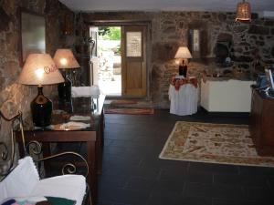 a living room with two lamps and a room with a table at Outros Tempos - Turismo de Aldeia in Armamar