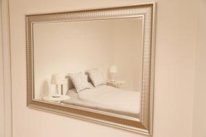 un miroir suspendu au mur avec un lit dans l'établissement Apartman - Heart of Budapest, à Budapest