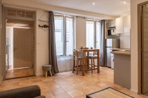 Il comprend une cuisine et un salon avec une table. dans l'établissement Studio Ingres au coeur historique de Montauban, à Montauban