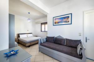 a living room with a couch and a bed at Honeymoon Beach Studios in Perivolos