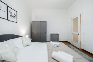 een witte slaapkamer met een groot bed met witte kussens bij The Brera Residence - 140SqM 3Bed2Bath in Milaan