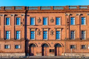 - un grand bâtiment en briques avec des fenêtres et des portes dans l'établissement Studio Ingres au coeur historique de Montauban, à Montauban