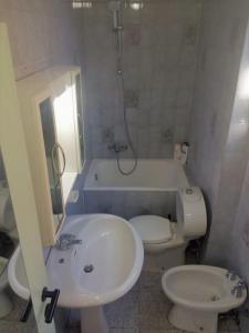 een badkamer met een wastafel, een toilet en een bad bij Bologna Maison Primaticcio in Bologna
