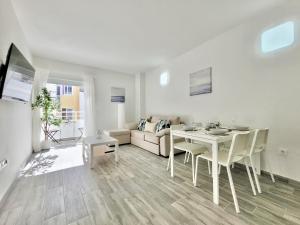 Biały salon ze stołem i kanapą w obiekcie La Hoya 29 Apartments w Puerto de la Cruz