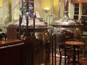 a room with two large containers and a table and chairs at The Old Cannon Brewery in Bury Saint Edmunds