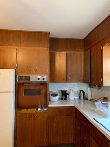 a kitchen with wooden cabinets and a white refrigerator at #1 Bright Private Room near New Brunswick, NJ downtown in New Brunswick