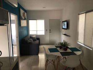 a living room with a table and a couch at Hermosos departamentos Ciudad Mayakoba in Playa del Carmen