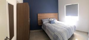a bedroom with a bed with a blue wall at Hermosos departamentos Ciudad Mayakoba in Playa del Carmen +9 photos