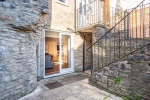 a stone house with a sliding glass door at Polly's Folly in Swanage