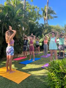 a group of people doing yoga in the grass at Indiana Kite school and Hostel in Cumbuco