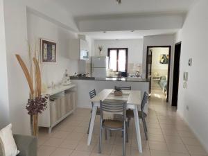 a kitchen and dining room with a table and chairs at Oasis del Sur in Puerto Madryn