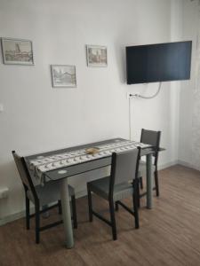 stół z 2 krzesłami i telewizor w pokoju w obiekcie Appartamento AL PARCO w Padwie