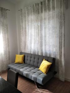 kanapę z 2 żółtymi poduszkami w salonie w obiekcie Appartamento AL PARCO w Padwie