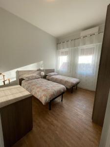 sypialnia z 2 łóżkami i oknem w obiekcie Appartamento AL PARCO w Padwie
