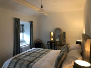 a bedroom with a bed and a window at Mistletoe Cottage in Foulridge