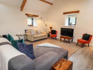 a living room with a couch and a tv at Castle Mill in Newport Pembrokeshire