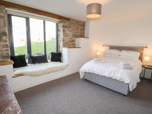 ein Schlafzimmer mit einem Bett und einem großen Fenster in der Unterkunft Castle Mill in Newport