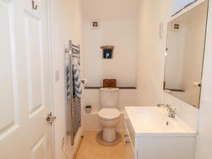 a white bathroom with a toilet and a sink at Castle Mill in Newport Pembrokeshire +31 photos
